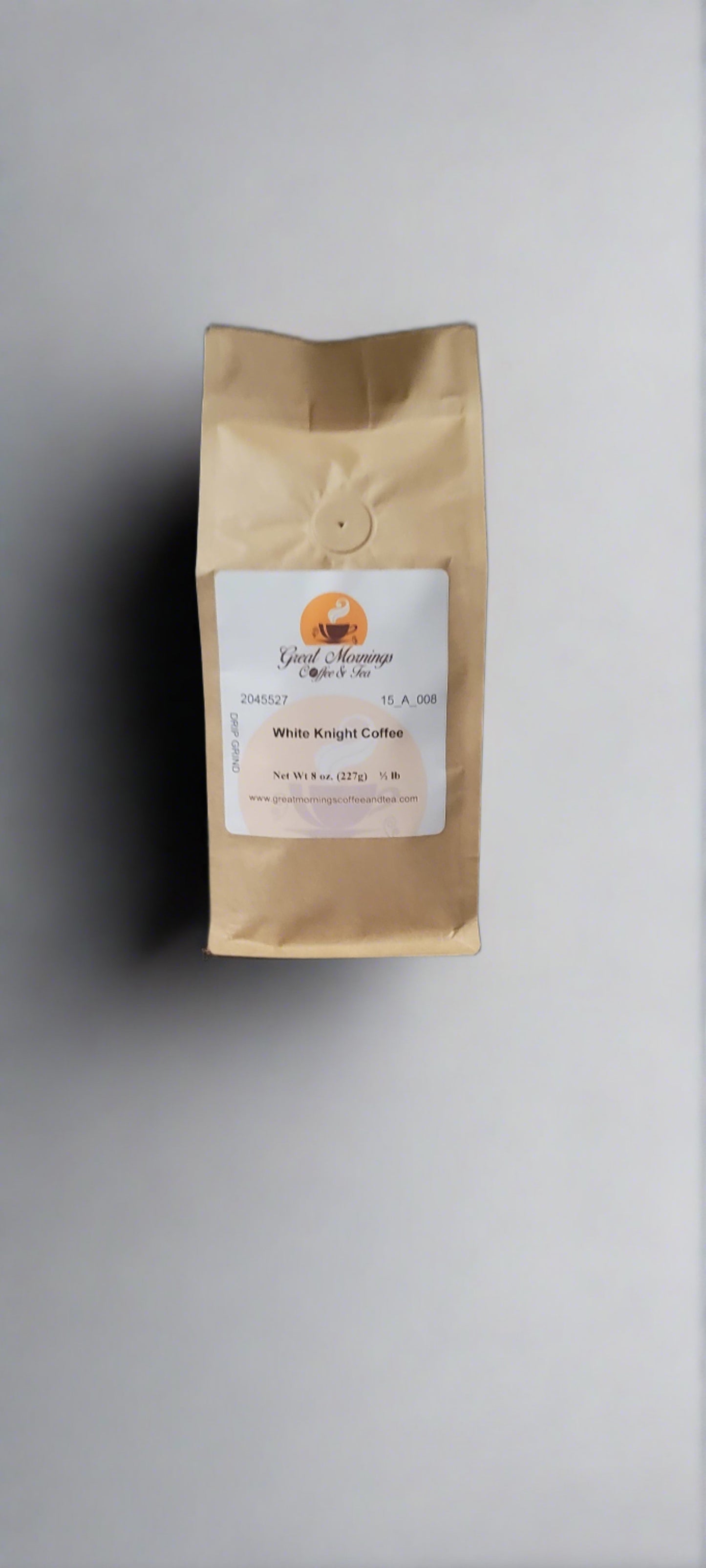 A photo of a standing brown paper coffee bag on a light gray background. The bag has a white label at the center with the orange and brown logo "Great Mornings Coffee & Tea" above the text "White Knight Coffee." Below, the label specifies "Net Wt 8 oz. (227g) ½ lb" with the website "www.greatmorningsofcoffeeandtea.com" at the bottom.