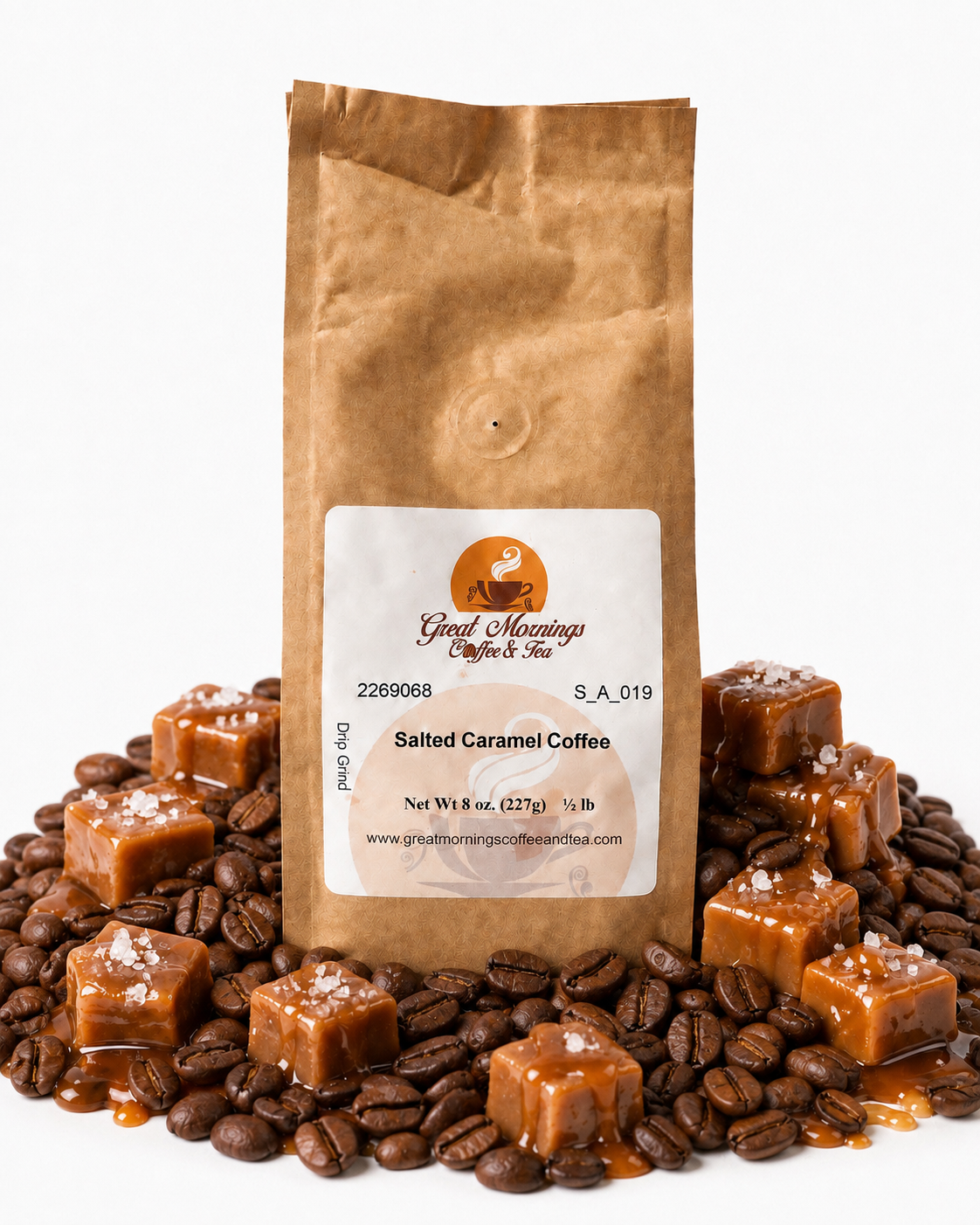 A brown kraft paper bag of Great Mornings Coffee & Tea Salted Caramel Coffee stands upright on a white background, surrounded by roasted coffee beans, caramel cubes with sea salt, and caramel drizzle. The bag label shows the brand 'Great Mornings Coffee & Tea'.