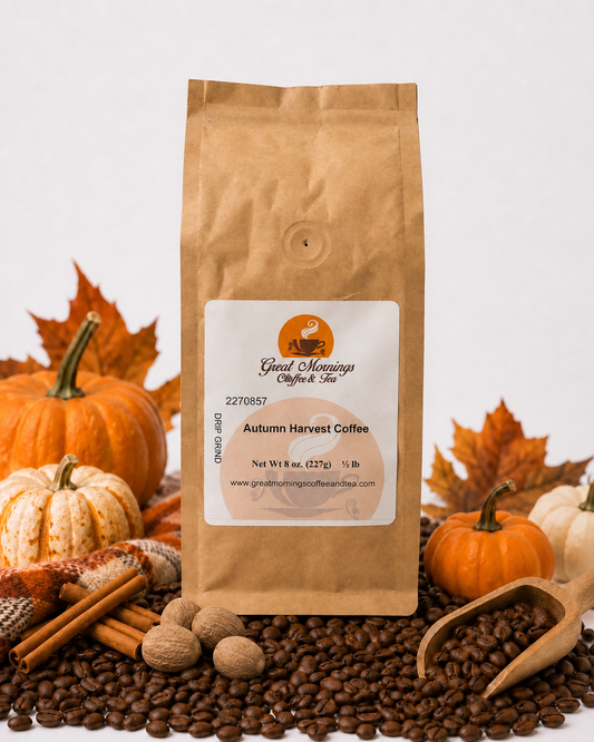 Great Mornings Autumn Harvest Coffee in a kraft paper bag on a white studio background, surrounded by roasted coffee beans, whole nutmeg, cinnamon sticks, small pumpkins, autumn leaves, and a warm plaid blanket.