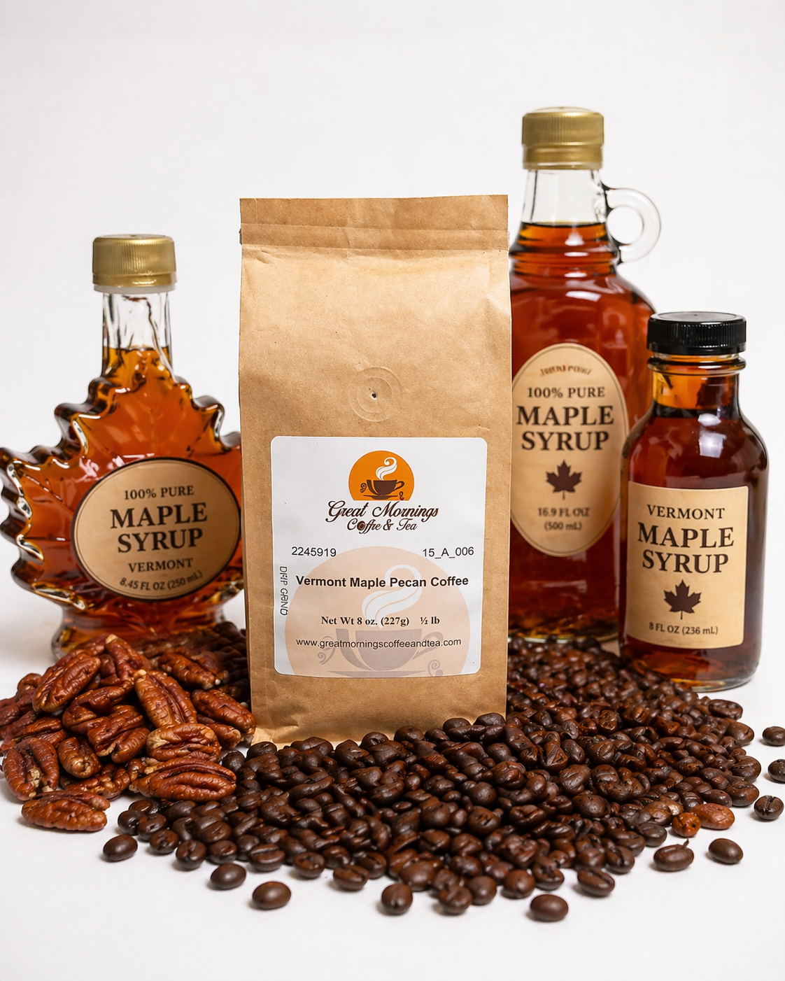 Three bottles of Vermont maple syrup, a bag of coffee beans, and a bag of pecans on a white background.