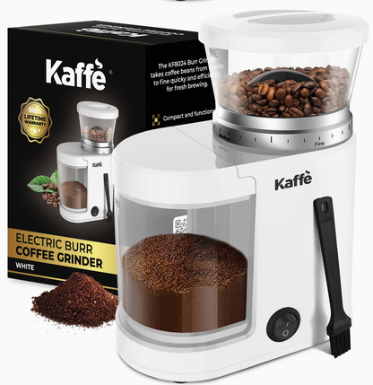 White Kaffé electric burr coffee grinder with a clear bean hopper filled with coffee beans, a clear bean hopper filled with ground coffee, a black cleaning brush, and the product packaging box in the background.
