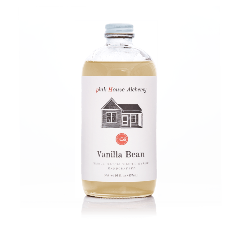 A clear bottle of vanilla bean syrup with white label from pink house alchemy