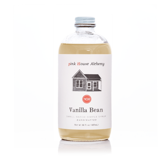 A clear bottle of vanilla bean syrup with white label from pink house alchemy